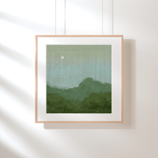 Framed artwork with a green gradient landscape on a white wall